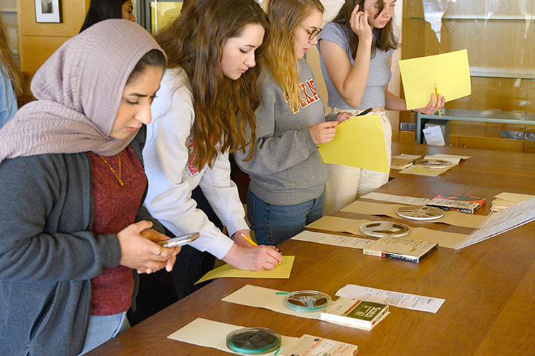 Undergraduate students examining archival materials